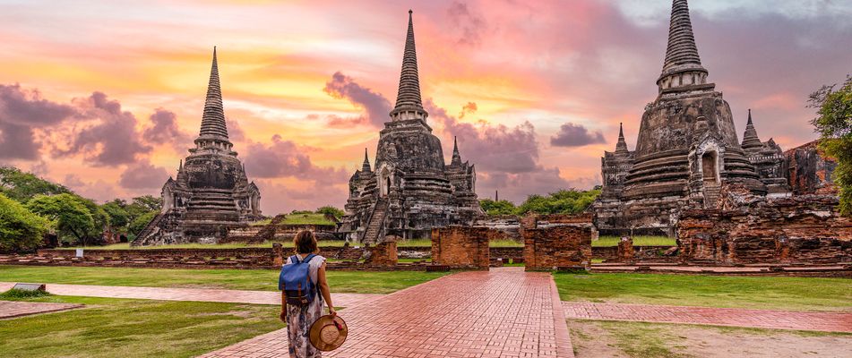 Eine Frau wandert durch die Tempelanlagen von Ayutthaya