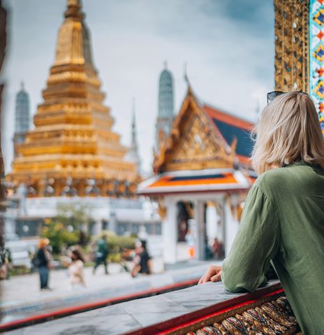 Frau blickt auf Tempel in Bangkok