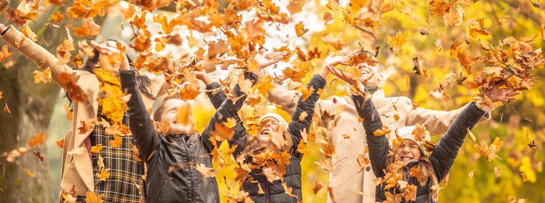 Menschen im Herbst voller Blätter