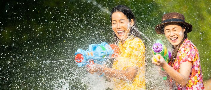 Menschen mit Wasserpistolen beim Songkran Fest