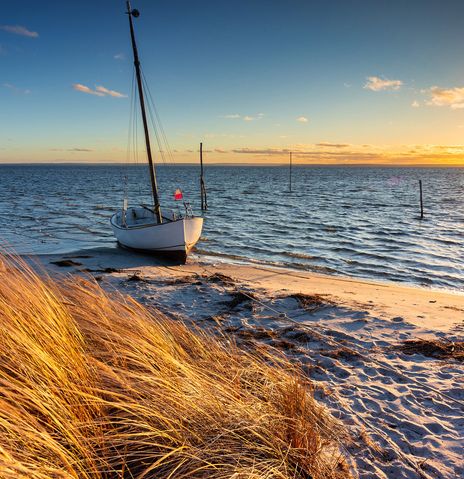 Ein Boot am Strand bei Sonnenuntergang