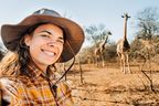 Frau macht ein Selfie mit Giraffen bei einer Safari in Südafrika
