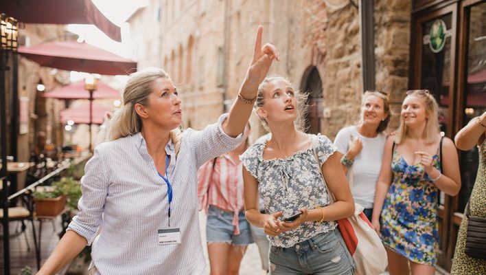 Reisegruppe mit Reiseleiterin bei einer geführten Rundreise durch eine historische Altstadt