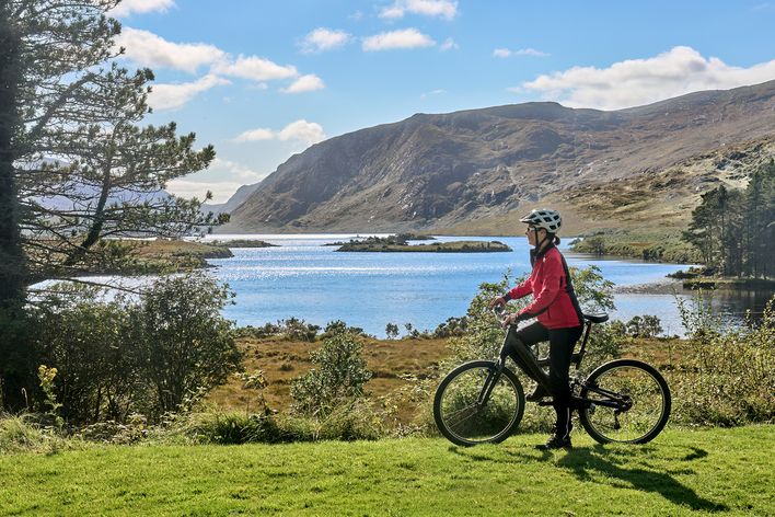 Frau auf dem Fahrrad am Lough Beagh im Glenveagh-Nationalpark