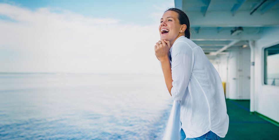 Fröhliche Frau auf Kreuzfahrtschiff