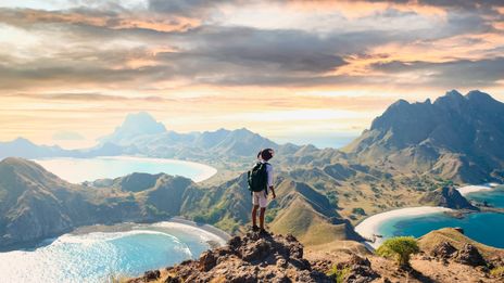 Mann mit Rucksack blickt im Komodo-Nationalpark auf der Insel Padar in Indonesien