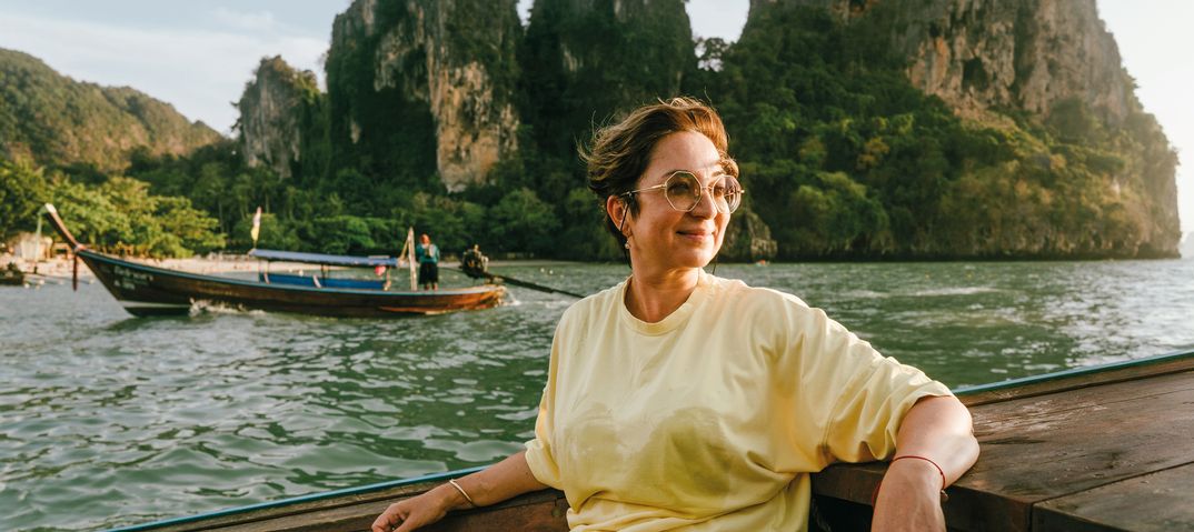 Frau genießt eine Bootsfahrt vor den Kalksteinfelsen der thailändischen Inselwelt bei Krabi