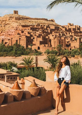 Eine Frau blickt auf die historischen Lehmbauten von Ait-Ben-Haddou 