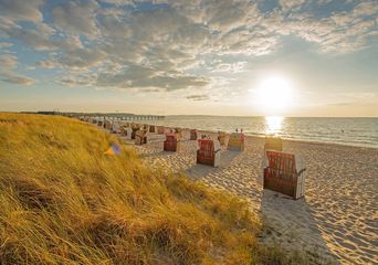Der Weissenhäuser Strand in Mecklenburg Vorpommern mit Strandkörben während des Sonnenuntergangs