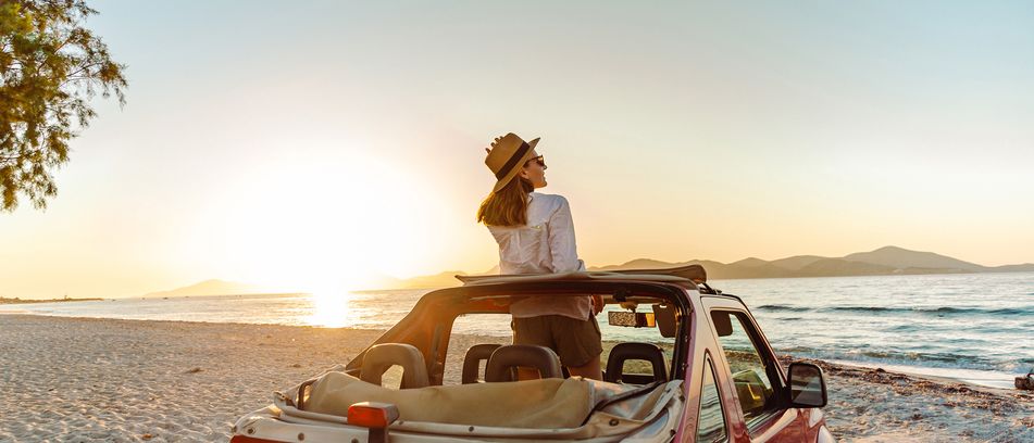 Frau im Auto am Meer