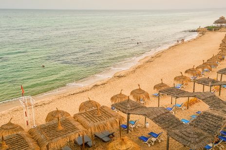 Blick auf den Strand von Hammamet mit Sonnenschirmen und Liegen in Tunesien aus der Vogelperspektive