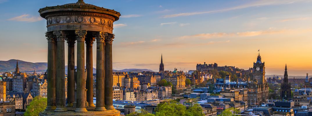 Panoramablick über Edinburgh mit Calton Hill und historischer Altstadt bei Sonnenuntergang