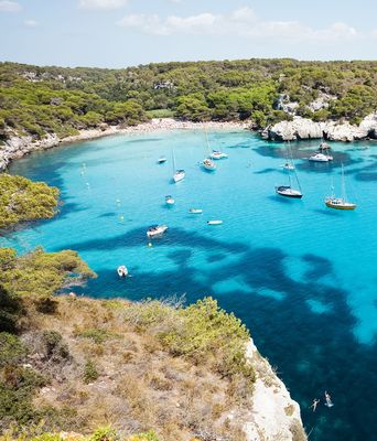 Blick auf Strand und Felsen in der Bucht Cala Macarelleta auf den Balearen auf Menorca in Spanien