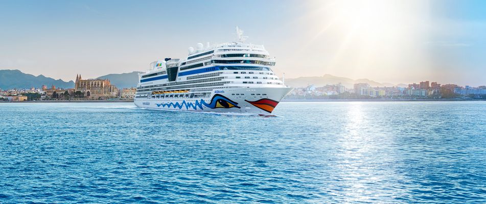 Das Schiff AIDAstella vor der Küste von Mallorca mit der Kathedrale im Hintergund