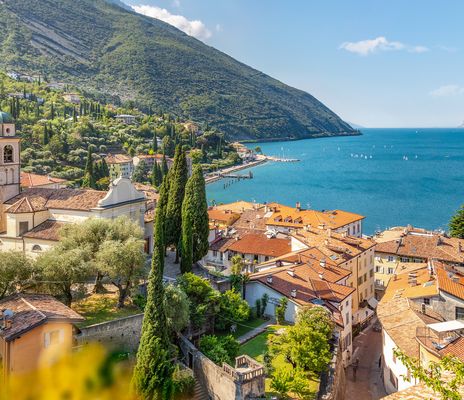 Blick auf Torbole am Gardasee mit Altstadt, Kirche, grünen Hügeln und Gardasee im Hintergrund