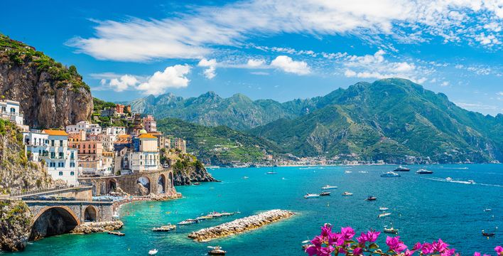 Panoramablick auf ein buntes Bergdorf am Meer mit Felsen, Bergen und Blumen an der Amalfiküste in Italien