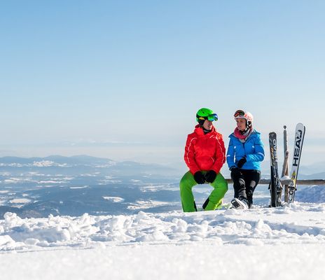 Paar macht Pause vom Skifahren auf dem Gipfel