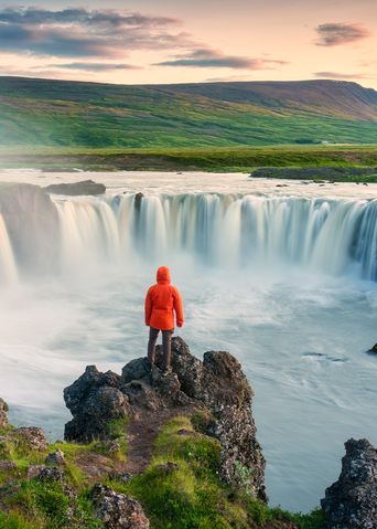 Mann vor einem Wasserfall auf Island
