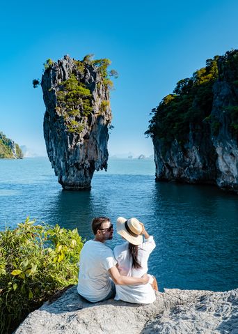 Ein Paar sitzt auf einem Felsen und betrachtet den James Bond Felsen in Phuket