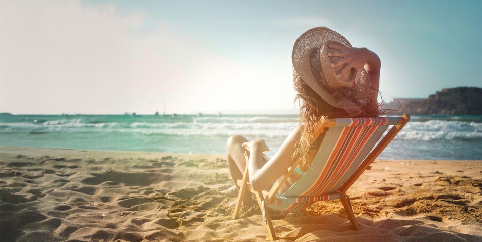 Frau im Liegestuhl am Strand