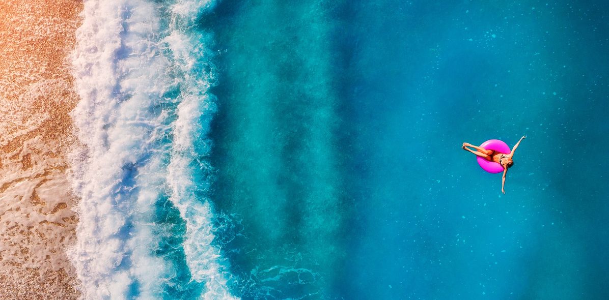 Frau im Schwimmreifen auf dem Meer
