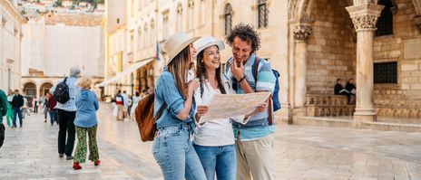 Freunde erkunden die Stadt Dubrovnik mit einem Stadtplan in der Hand