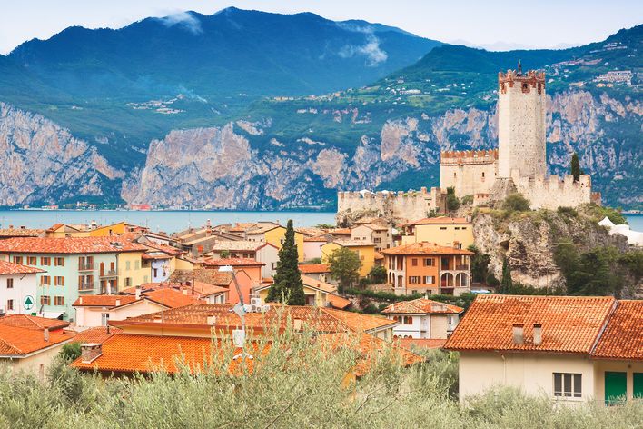 Blick auf Malcesine am Gardasee mit der Scaligerburg, bunten Häusern und den Bergen im Hintergrund