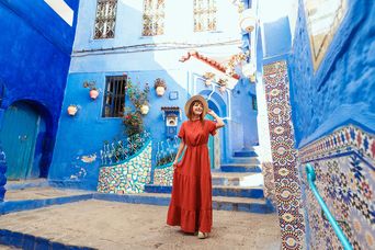 Frau spaziert durch die blauen Gassen von Chefchaouen in Marokko