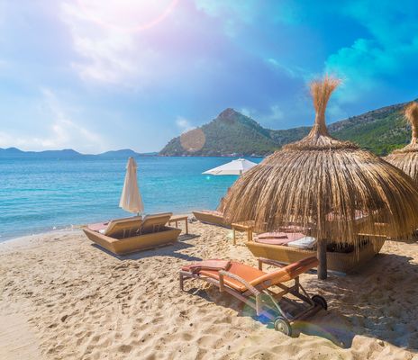 Strand mit Liegen und Strohschirmen auf den Balearen 