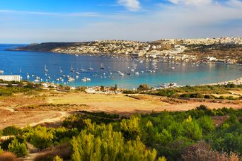 Weitblick auf die Bucht von Mellieha Bay mit der gleichnamigen Stadt im Hintergrund auf Malta