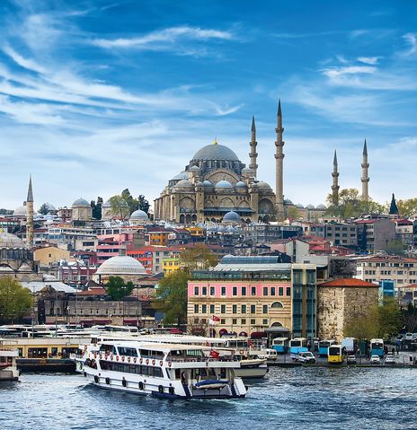 Panoramaansicht vom Bosporus aus über den Hafen mit Fähren auf ein Viertel in Istanbul in der Türkei, wobei die majestätische Süleymaniye-Moschee das Stadtbild auf einem Hügel dominiert