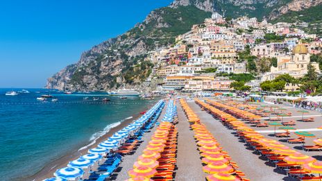 Strand von Positano mit bunten Sonnenschirmen und Amalfiküste