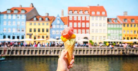 Bunte Eistüte vor den farbenfrohen Häuserfassaden in Kopenhagen, Dänemark