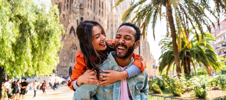 Lachendes Paar vor der Sagrada Familia in Barcelona bei Sonnenschein
