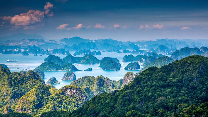 Panoramablick auf die Halong-Bucht mit Nebel, Inseln und ruhigem Wasser