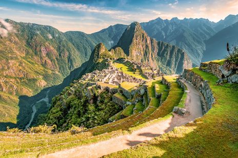 Panoramablick auf Machu Picchu mit Serpentinenweg und grünen Berghängen