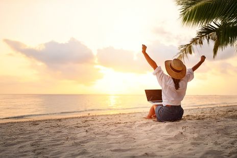 Frau mit PC am Strand