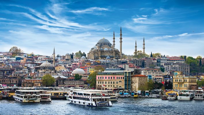 Panoramaansicht vom Bosporus aus über den Hafen mit Fähren auf ein Viertel in Istanbul in der Türkei, wobei die majestätische Süleymaniye-Moschee das Stadtbild auf einem Hügel dominiert