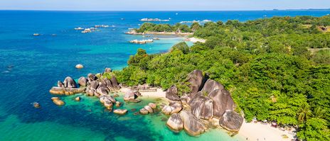 Luftaufnahme des Tanjung Tinggi Beach auf Belitung mit Granitfelsen und türkisfarbenem Meer