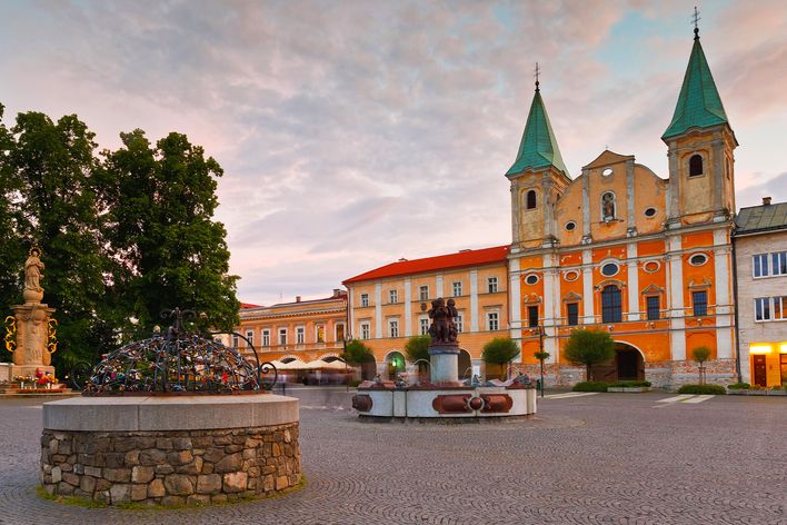 Zentralplatz von Žilina mit historischer Architektur, Kirche und Brunnen