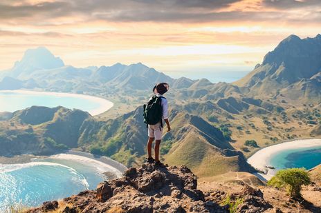 Mann mit Rucksack blickt im Komodo-Nationalpark auf der Insel Padar in Indonesien