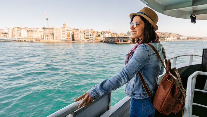 Eine Frau steht an der Reling und genießt die Aussicht auf den Fluss vom Deck aus
