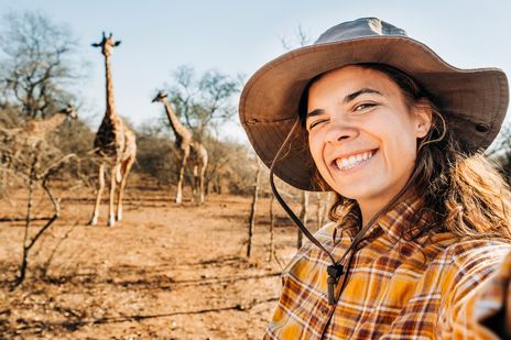 Frau macht ein Selfie mit Giraffen bei einer Safari in Südafrika