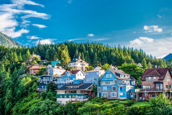 Bunte Holzhäuser in Ketchikan an bewaldetem Hang in Alaska