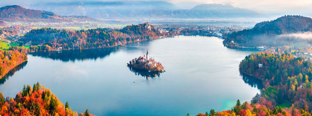 Bleder See mit Inselkirche und umliegenden Bergen in Slowenien