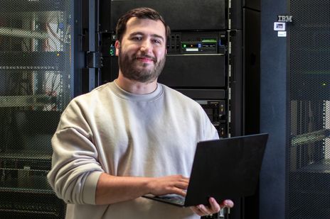 Mitarbeiter Dominik steht im Serverraum der IT