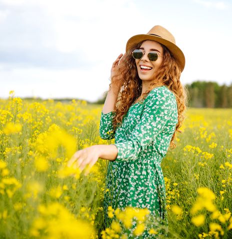 Frau steht in einer Blumenwiese