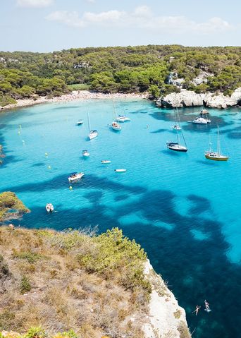 Blick auf Strand und Felsen in der Bucht Cala Macarelleta auf den Balearen auf Menorca in Spanien