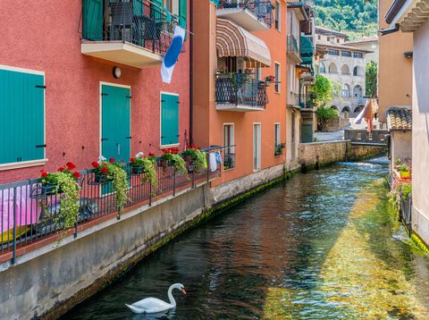 Der Aril-Fluss in Cassone am Gardasee, gesäumt von bunten Häusern und kleinen Brücken