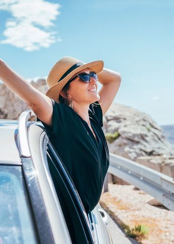 Frau im Auto am Strand
